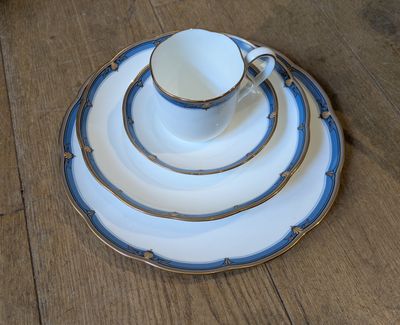 a stack of plates with a cup and saucer on top of it