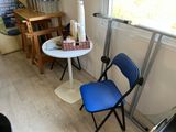 une chaise bleue et une table blanche dans un coin de la pièce