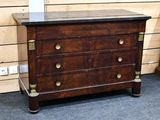 a wooden chest of drawers with a marble top