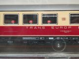 un wagon rouge et jaune qui est à l'arrêt sur les rails