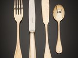 three forks, a knife, and a spoon on a black background
