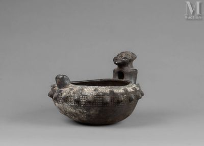 an image of a black pottery bowl with a boy sitting on it