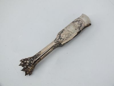 a silver spoon on a white plate with a silver handle