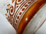 a close up of a glass with a brown design on it