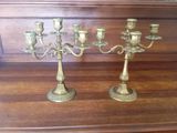 two brass candelabs sitting on a wooden table