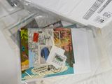 a picture of a package of postcards and envelopes sitting on a bed