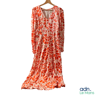 an orange and white dress on a hanger on a white background