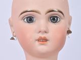 a close up of a doll with a bald head and blue eyes
