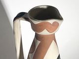 a white vase with a brown and black design on it