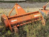 a small orange machine that is sitting in the grass