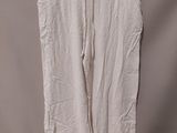 the white pants are hanging on a hanger in front of a wall