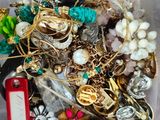 a plastic container filled with assorted jewelry and other items