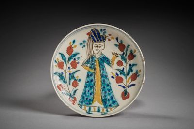 une image représentant une assiette décorative sur laquelle figure une femme en robe bleue