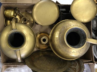 a lot of brass items in a box on the floor