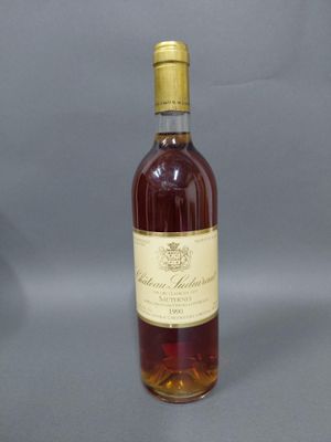 une bouteille de vin posée sur une table à côté d'un verre