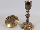 pair of antique brass candlesticks and a plate on a white background