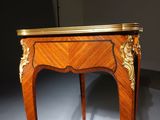 an antique wooden table with gold trimming and a marble top