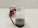 a glass with a red wire on it on a table