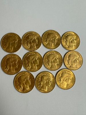 six types différents de pièces d'or sont disposés sur une surface blanche