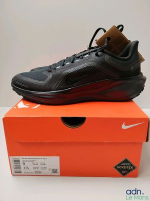 La Nike Air Max noire et rouge est posée sur une boîte