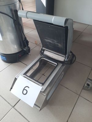 des toilettes posées à même le sol, à côté d'une poubelle