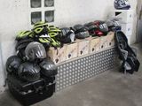 a pile of helmets sitting on a bench in a garage