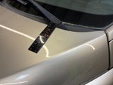 a sticker on the hood of a car that is parked in a parking lot