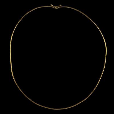 a gold necklace on a black background