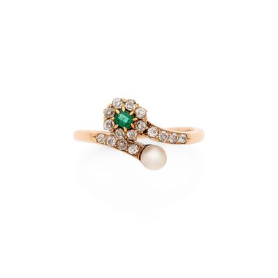 un gros plan d'une bague sertie d'une perle et d'une émeraude