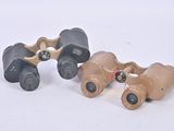 two binoculars are sitting next to each other on a white surface