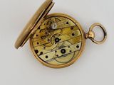 an image of a pocket watch with a gold case on a white surface