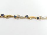 un gros plan sur un bracelet en or orné de pierres bleues et blanches