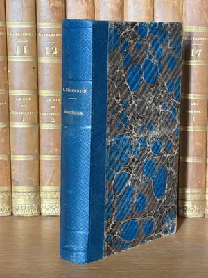 un livre posé sur une étagère, devant une pile de livres