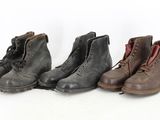 trois paires de bottes sont alignées sur une surface blanche