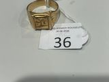 une bague en or posée sur une table blanche, avec une étiquette de prix dessus