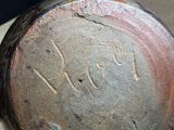 a close up of a brown vase with writing on it