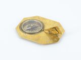 gold plated compass on a white surface with a white background