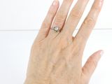 a woman ' s hand with a diamond ring on it