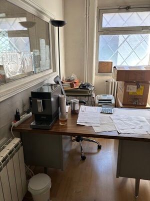 un bureau dans une pièce où s'entassent de nombreux papiers