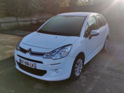 la petite voiture blanche est garée sur le bord de la route