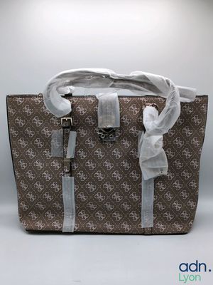 a brown and white bag with a white ribbon on the handle