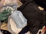 a pile of clothes sitting on top of a bed