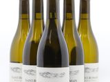 four bottles of wine are lined up on a white surface