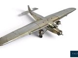 une maquette d'avion argentée posée sur une surface blanche