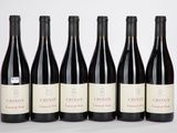 six bouteilles de vin rouge sont alignées