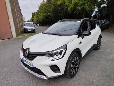 une voiture blanche garée dans un parking à côté d'un bâtiment