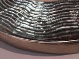 a large silver bowl with a spoon in it on a table