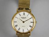 a gold wrist watch with roman numerals on it