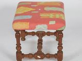 a small wooden stool with a colorful upholstered seat