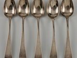 six cuillères sont alignées sur une table